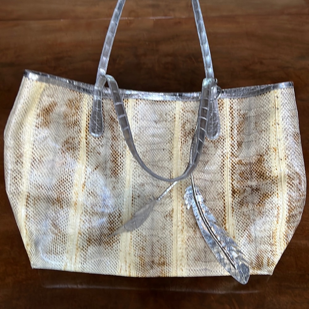 Nancy Gonzalez tote with silver feather and attached mini bag inside.